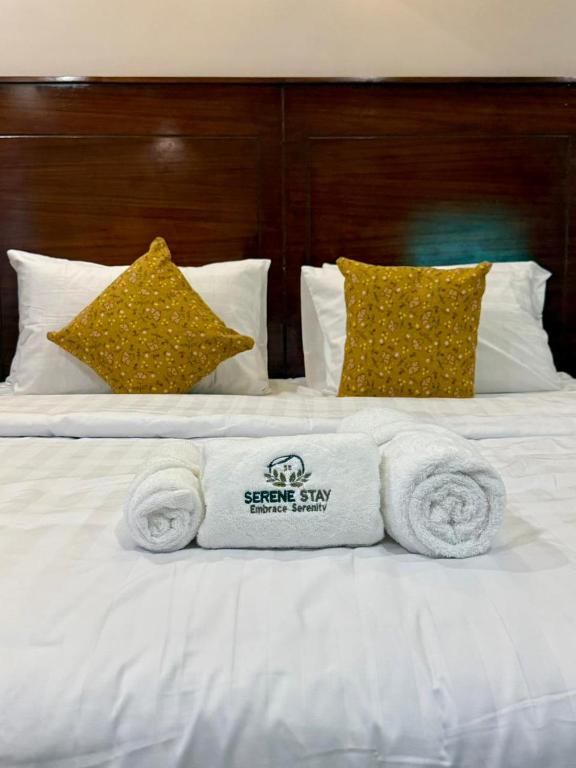 Una cama blanca con toallas y almohadas. en Serene stays, en Karachi