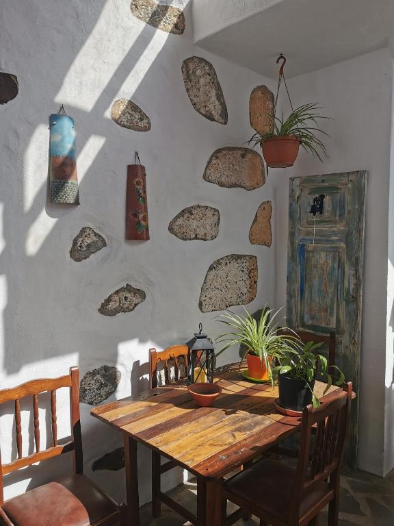 a room with a wooden table with rocks on the wall at Casa Gloria, encanto canario entre montaña y mar in Arucas