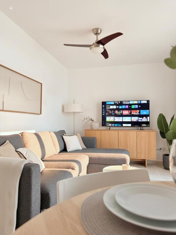 a living room with couches and a flat screen tv at Casa Estío - Renovated 1st line sea view apartment, pool access, AC - Calpe Costa Blanca in Ifach