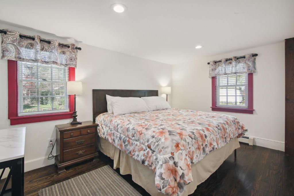 a bedroom with a bed and two windows at The Cottage Inn At Amos Lake in Preston