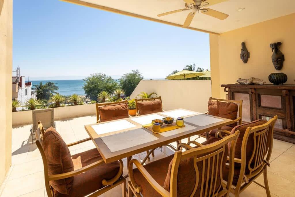 a dining room with a table and chairs and the ocean at Oceanview Condo in Faro de Mita in Punta Mita