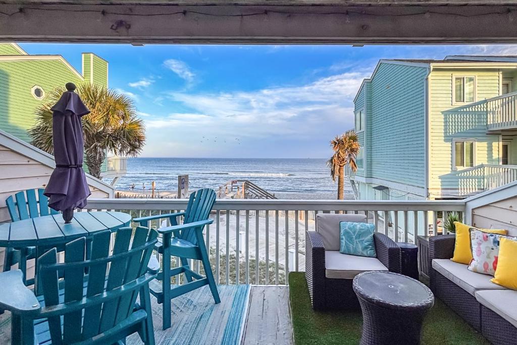 a balcony with a table and chairs and the ocean at Poolside Fun + Oceanfront Bliss: Kure Beach Haven! in Kure Beach