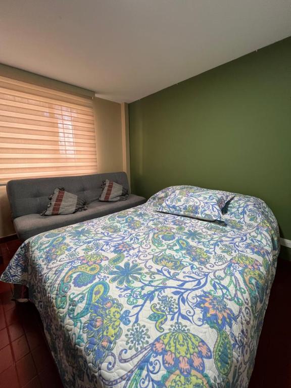 un dormitorio con una cama y un sofá en The Mountain Apto House, en Bogotá