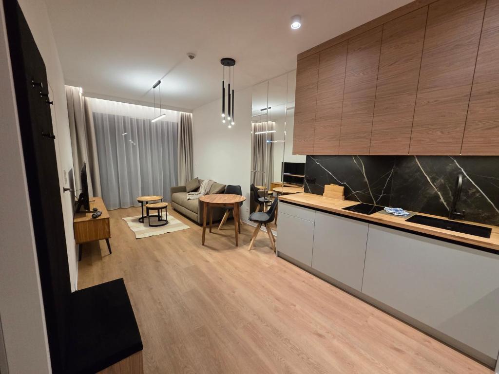 a kitchen and living room with a couch and a table at Omega Lake Family 1 in Olsztyn