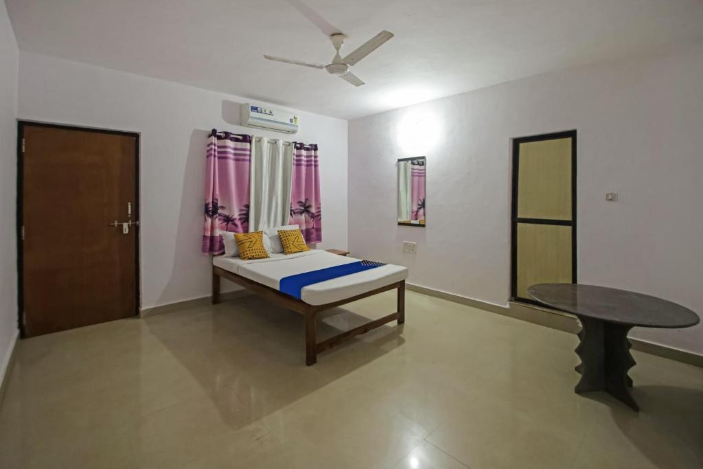 a room with a bed and a table in it at Hotel O Sunshine Guest House in Goa