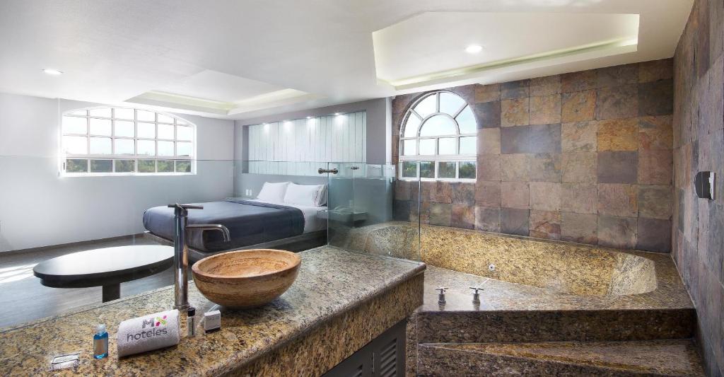 A spacious bathroom features a stone soaking tub, glass shower area, and bowl sink.