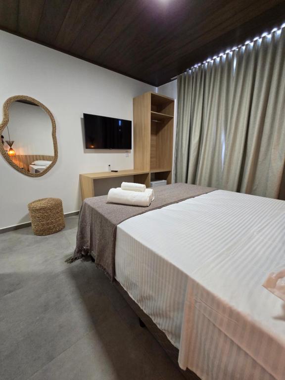 Un dormitorio con una cama grande y un espejo. en Portal do Kite, en Barra Grande