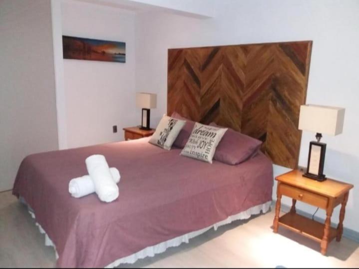 ein Schlafzimmer mit einem großen Bett mit zwei Nachttischen in der Unterkunft Mahiahouse in Santiago