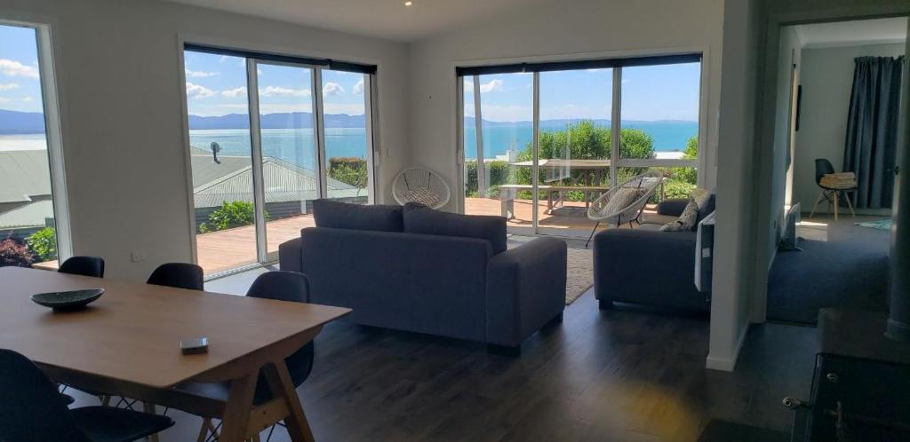 a living room with a couch and chairs and a table at Bay Vista - glorious Golden Bay Ocean Views in Pohara