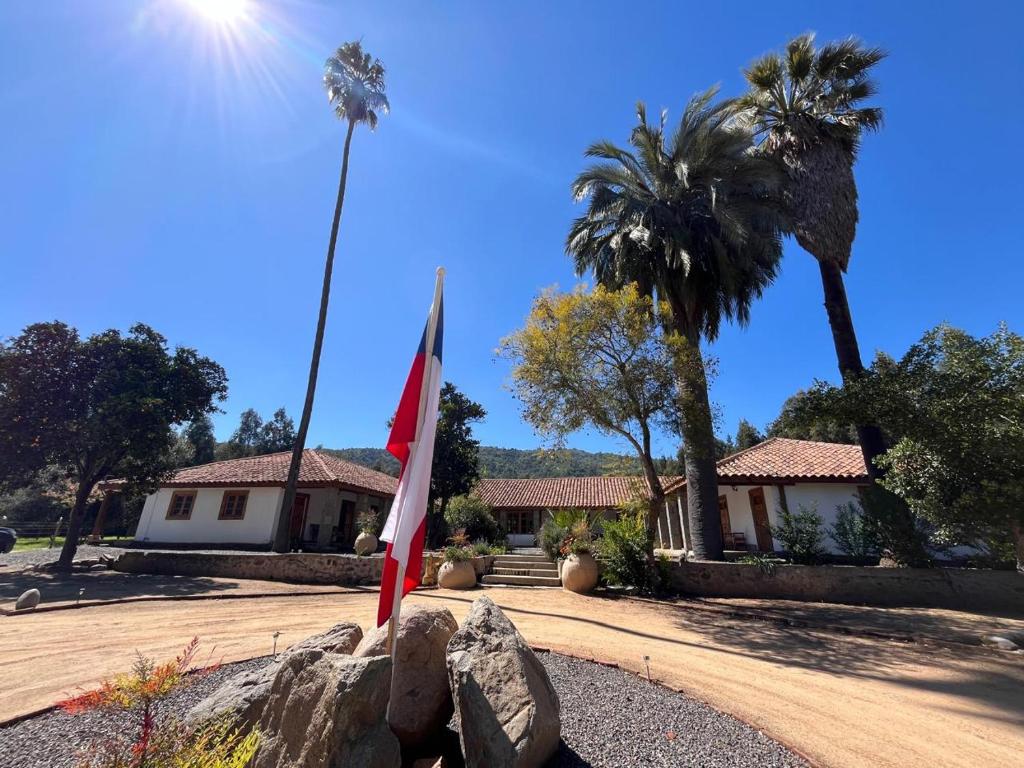 a house with a flag and a palm tree at Hacienda Ranguil in Lolol