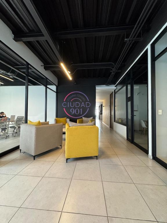 グアダラハラにあるFurnished loft in Ciudad Granja with balconyのソファ付きのロビーと壁に看板