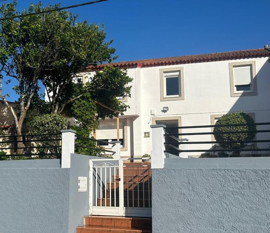 una casa bianca con un cancello davanti di Casa Carmen e do Hilario a Ponte Do Porto
