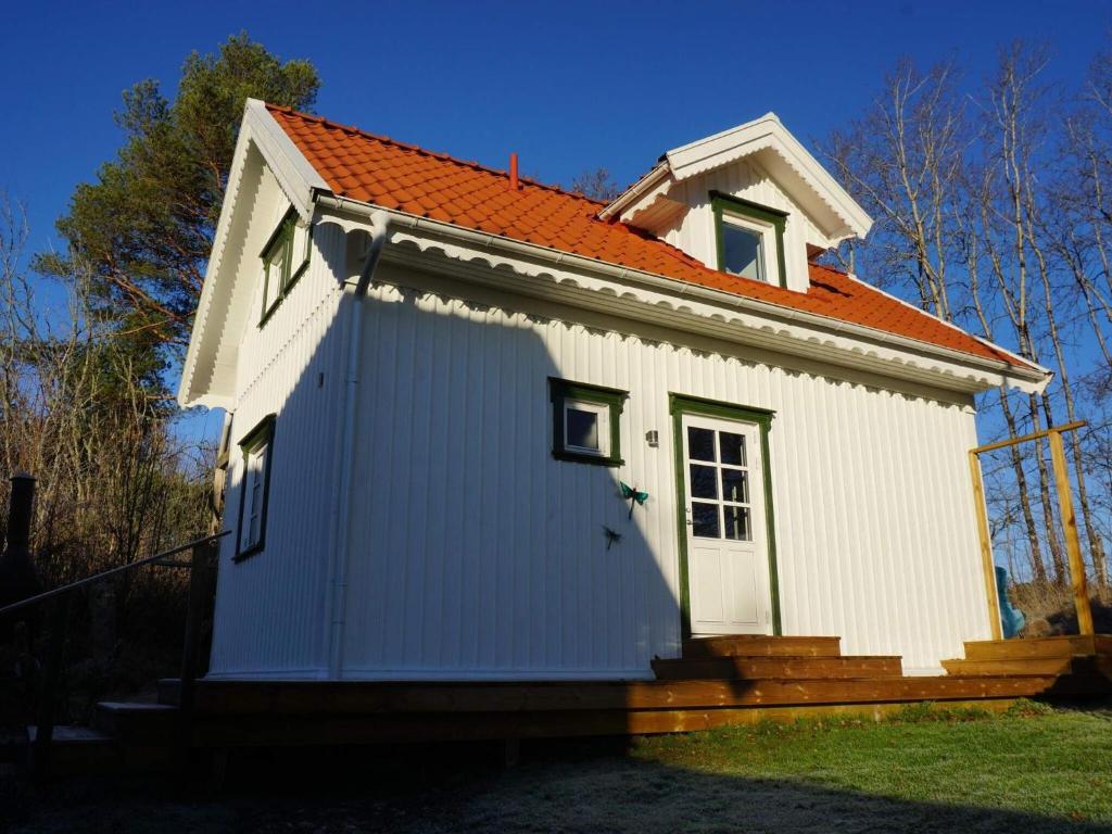 Tanum4 person holiday home in Tanumshede的一座白色的小房子,拥有橙色的屋顶