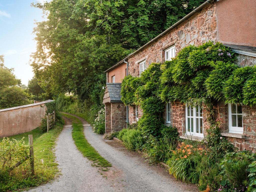 een stenen huis met klimop aan de zijkant bij Fursdon Cottage in Cadbury