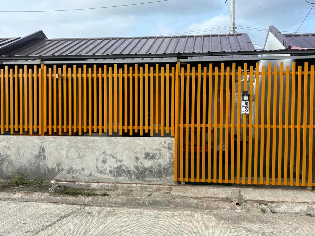 a building with a yellow gate on the side of it at Eko's Crib Unit 30 in Sampong