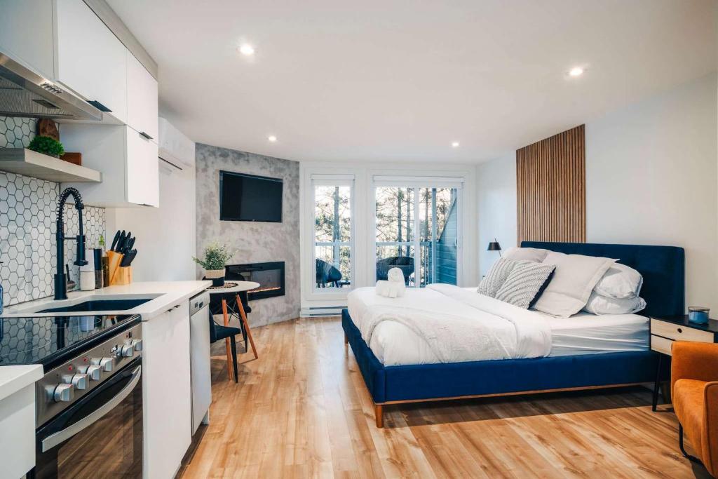 een slaapkamer met een groot bed en een keuken bij LAO LOFT 105 by Gestion ELITE in Mont-Tremblant
