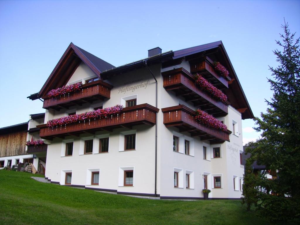 ein weißes Gebäude mit Balkonen und Blumen darauf in der Unterkunft Haflingerhof in Fiss