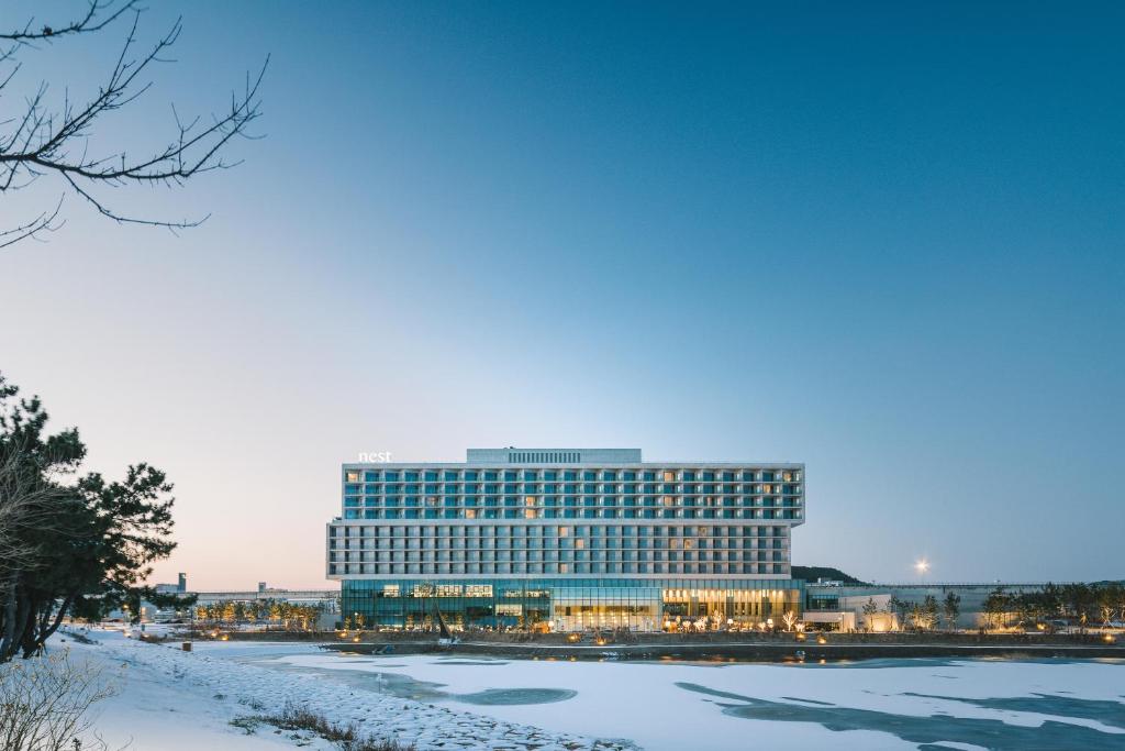 Un gran edificio con nieve delante. en Nest Hotel Incheon, en Incheon