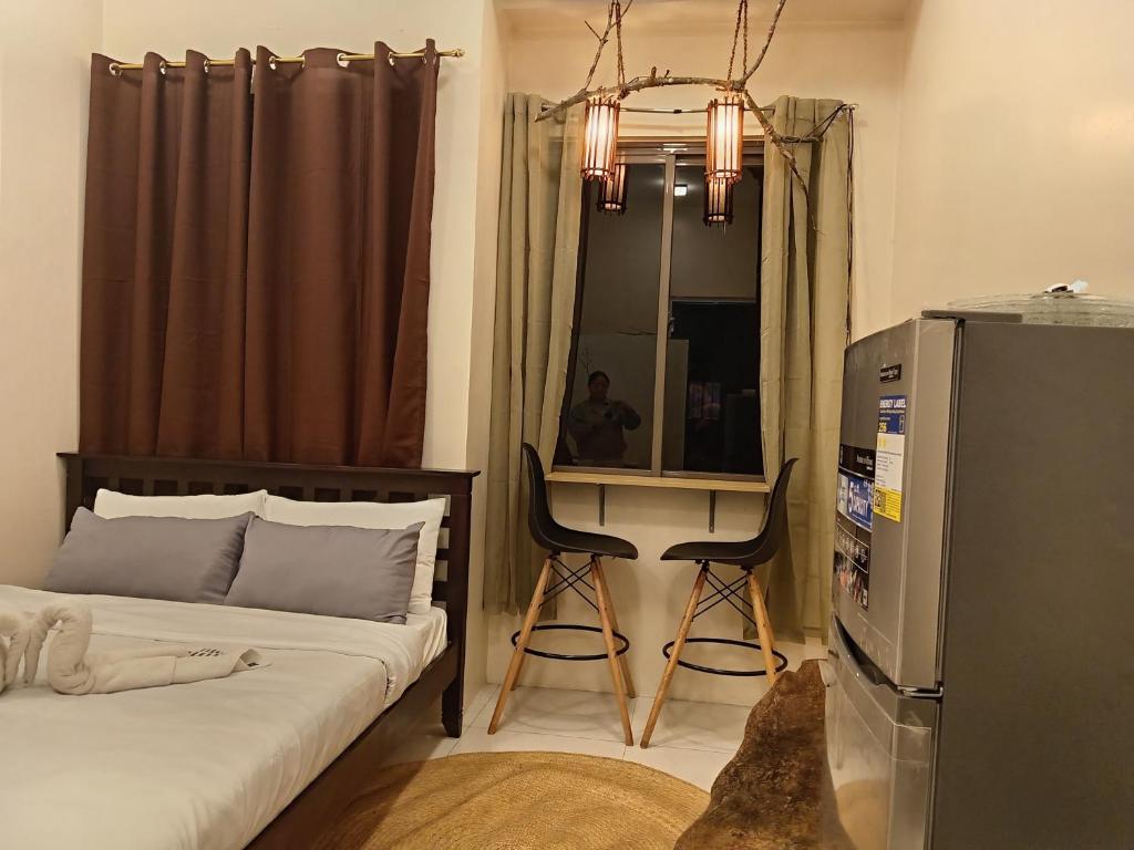 Un dormitorio con una cama y un escritorio con espejo. en Xybel Studio, en Baguio