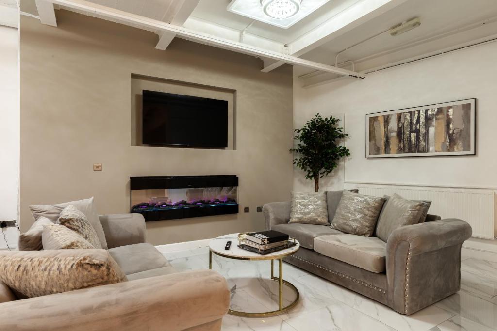 a living room with two couches and a tv at Skyway Luxury Stay with Jacuzzi in Bradford