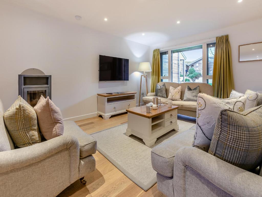 uma sala de estar com dois sofás e uma TV em Lodge 74 Una em Carbis Bay