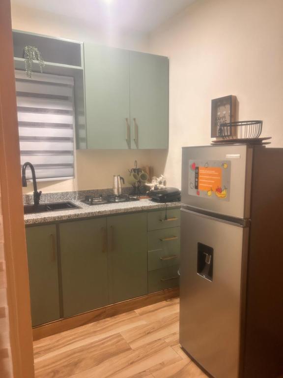 a kitchen with green cabinets and a refrigerator at El descanso in Higuey