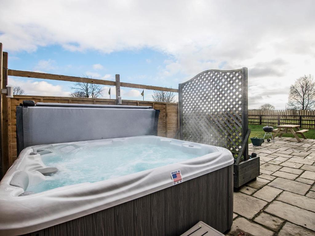 a hot tub sitting on top of a patio at Field View - Ukc2304 in Wainfleet All Saints