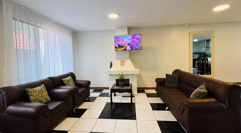 巴尼奥斯Mansion del Bosque with Jacuzzi 6 Bedroom 5 Bath的客厅设有2张棕色沙发和壁炉