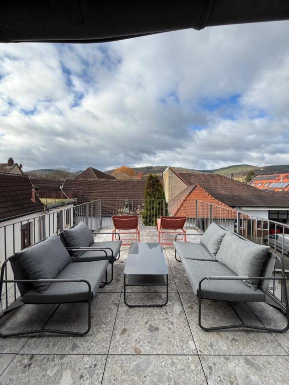 Un patio con sofás y una mesa y sillas. en Townhouse Mayfair Style im Weinstrassen Hotspot Deidesheim, en Deidesheim