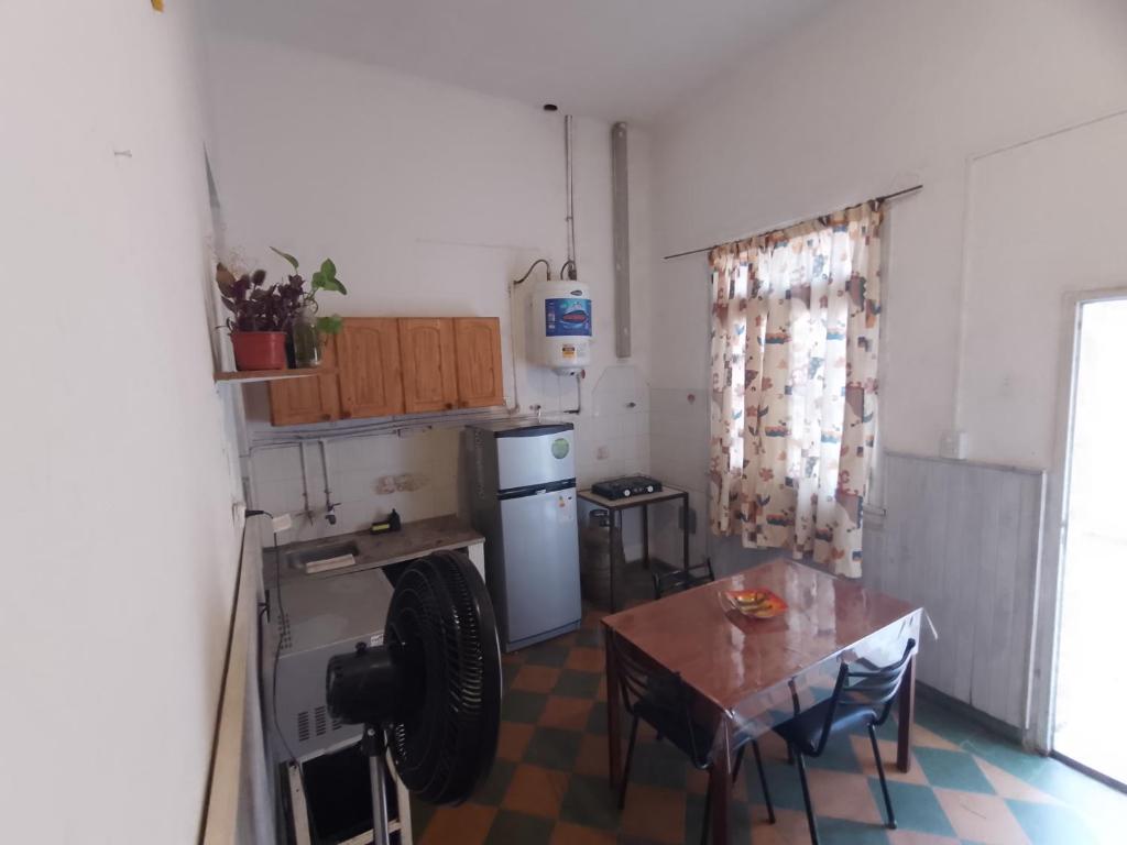 una cucina con un tavolo, un fornello e un frigorifero di Dpto 2 personas a Villa María