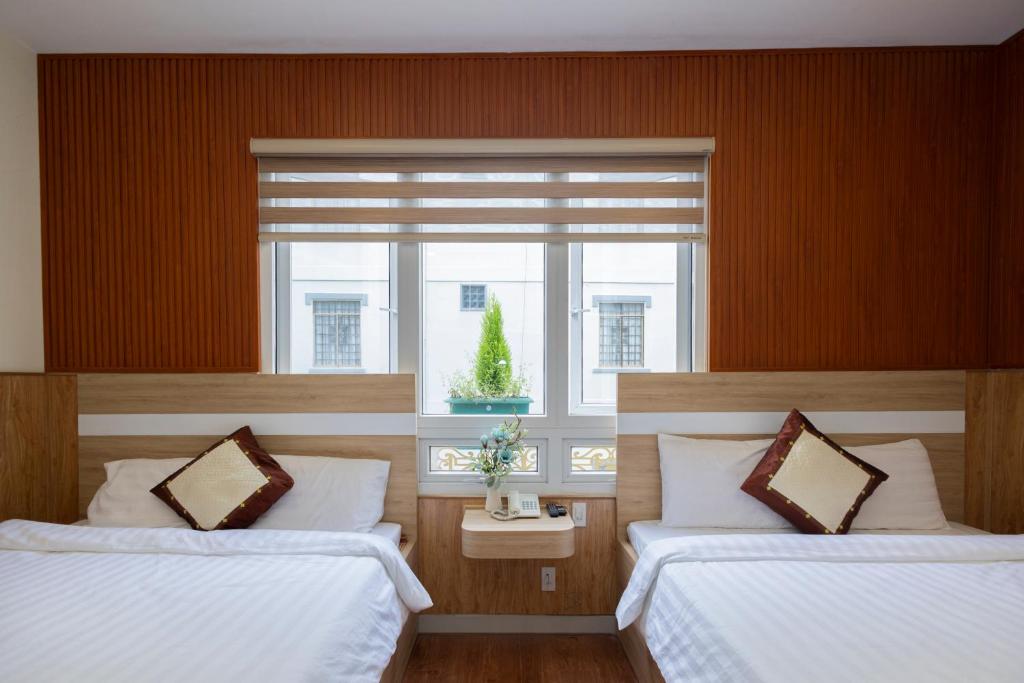 um quarto com duas camas e uma janela em NGỌC BẢO CHÂU HOTEL em Da Lat