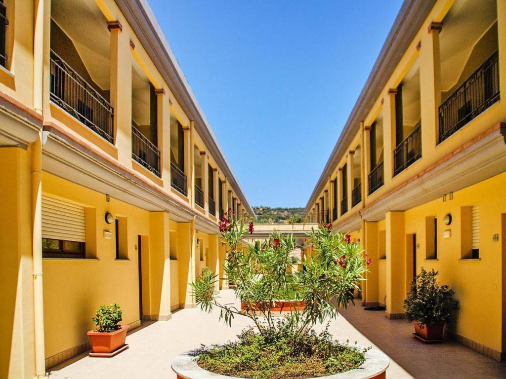 an empty courtyard of an apartment building with plants at Apartment with garden in Villasimius in Villasimius