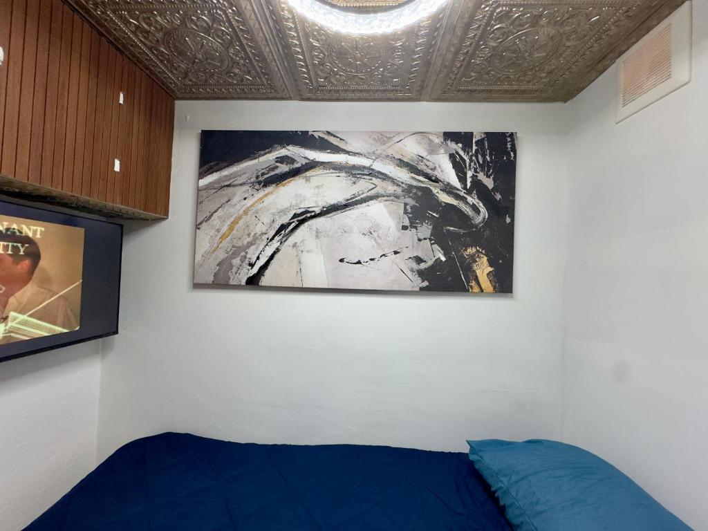 una camera da letto con un dipinto sul muro e un letto di Lux Pod Room a West Palm Beach