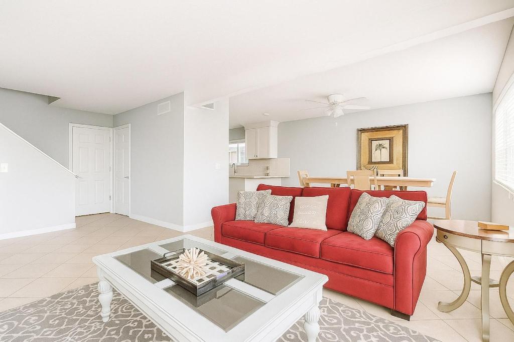 een woonkamer met een rode bank en een tafel bij Beachside Bliss - Neptune Nook Unit 1 in Jacksonville Beach
