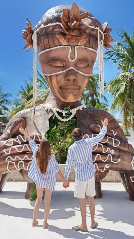 two people standing in front of a large statue at Casa Hamaca Nayarit in Chacala