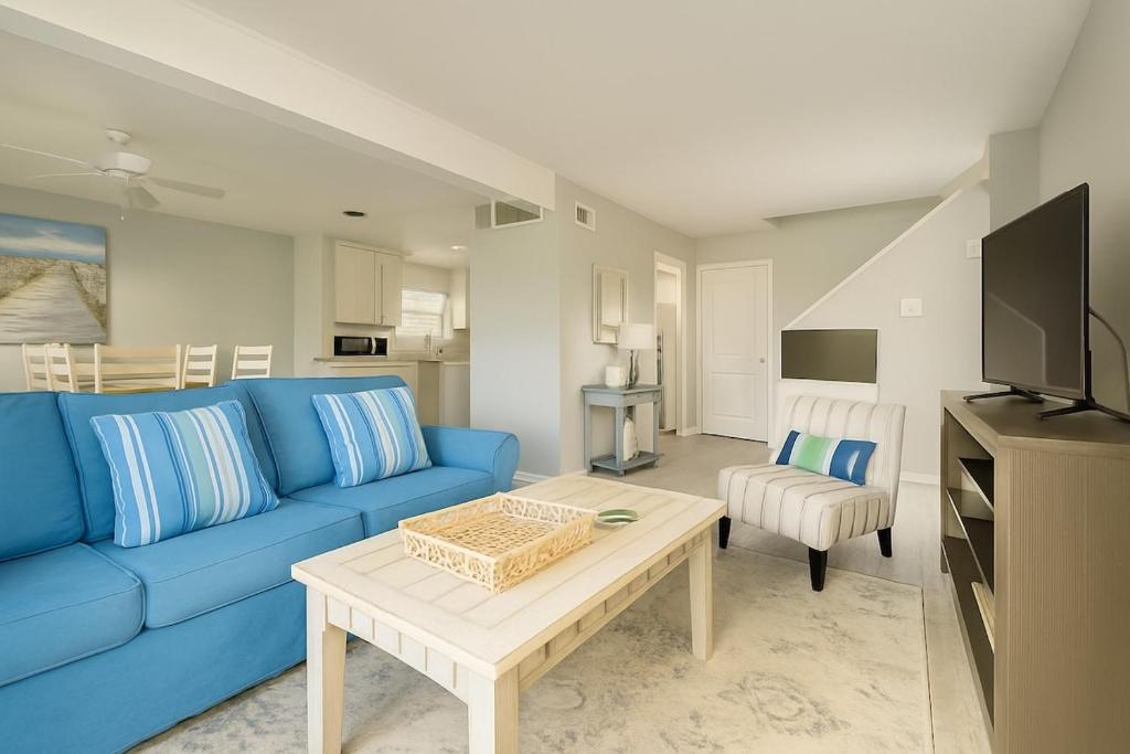 a living room with a blue couch and a table at Beachside Bliss - Neptune Nook Unit 2 in Jacksonville Beach