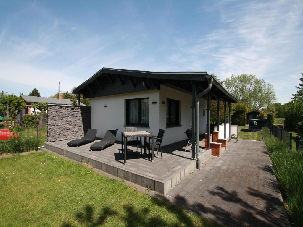 een huis met een terras met een tafel en stoelen bij Ferienhaus direkt an der Spree in Frauenberg