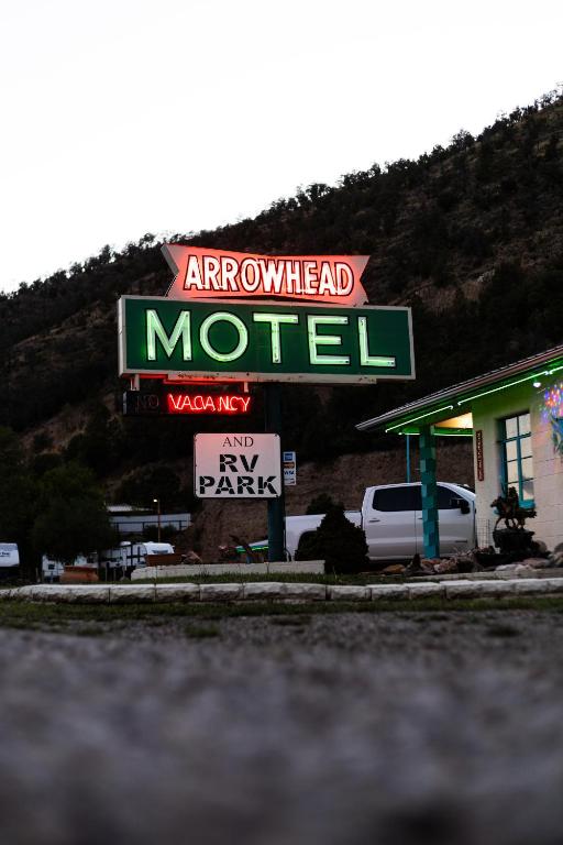 an arrowhead motel sign in front of a parking lot at Arrowhead Motel and RV Park in Ruidoso