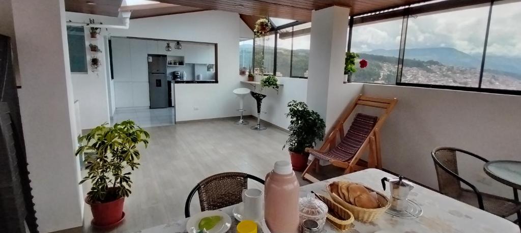 Una habitación con una mesa y sillas y una cocina. en Panoramic Cusco, en Cusco