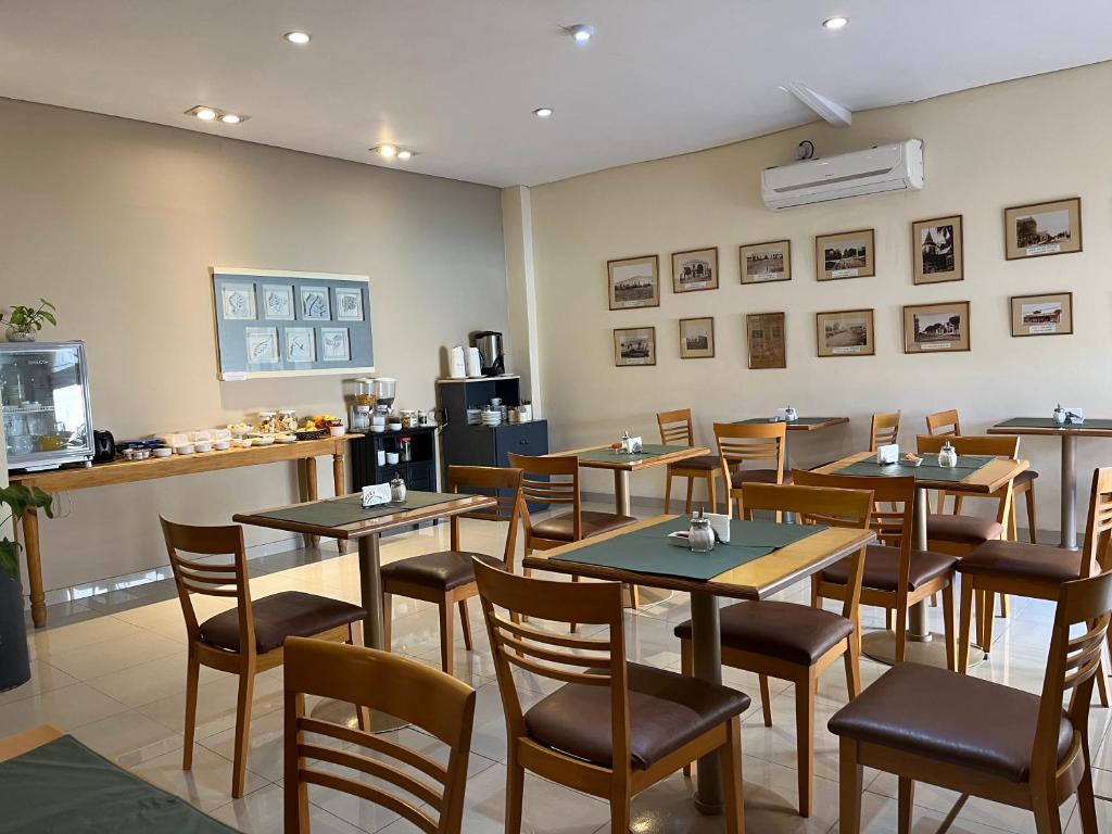 um restaurante com mesas e cadeiras em uma sala em HOTEL LOS TILOS RECONQUISTA em Reconquista