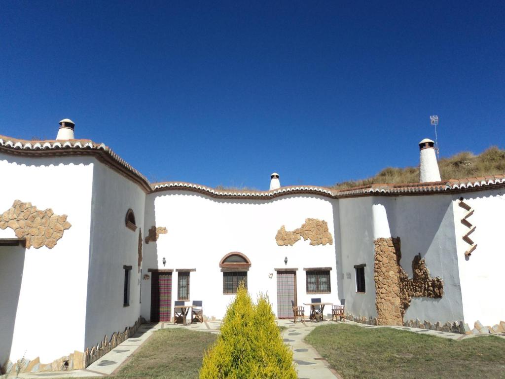 a large white building with two chimneys on top at Cave House in Guadix with Private Pool in Bejarín