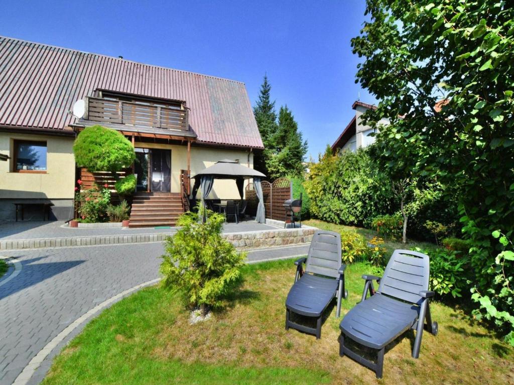 two lounge chairs in the yard of a house at Comfortable holiday home with a garden, Kolobrzeg in Luboszyce