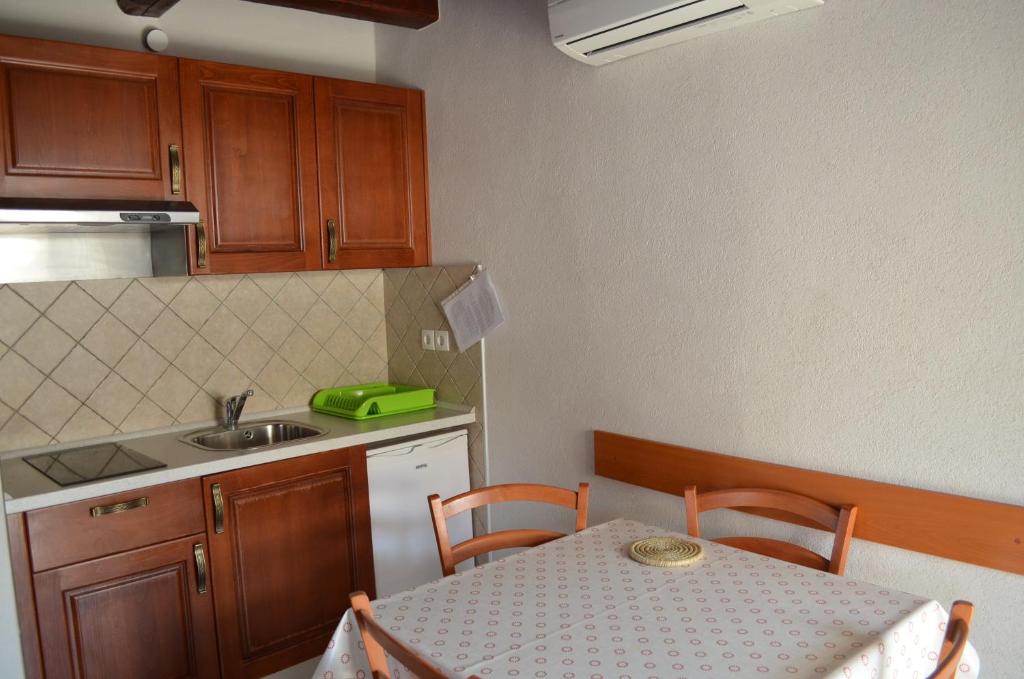 eine kleine Küche mit einem Tisch und einem Waschbecken in der Unterkunft Apartments Hedviga in Krk