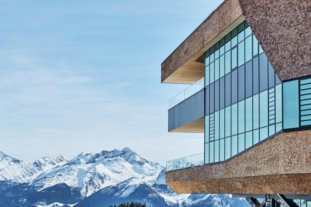 a building with mountains in the background at Apartment in Kaltenbach with Ski-In Ski-Out in Mühlfeld