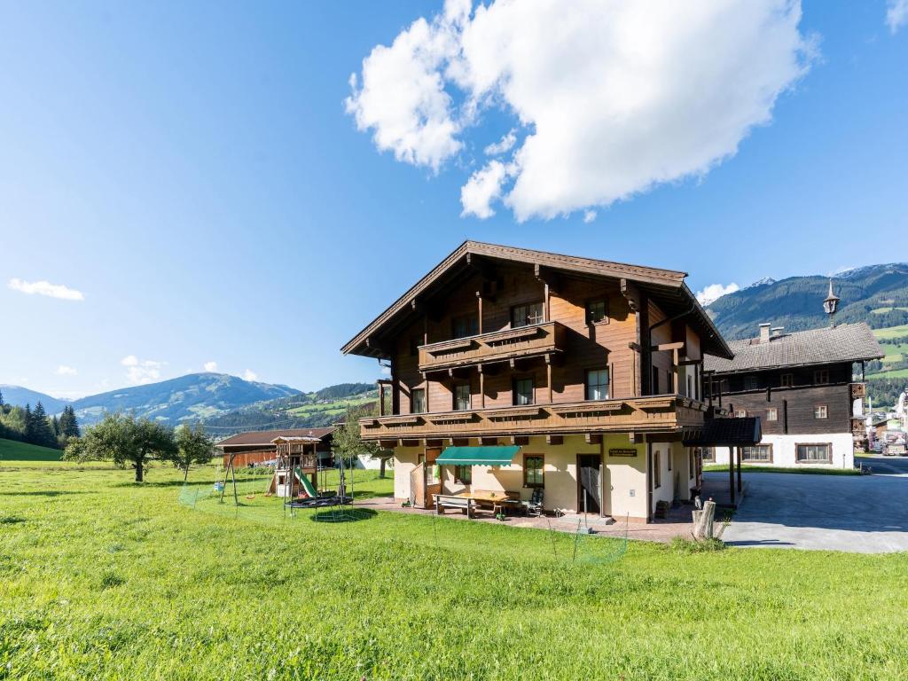 a large wooden house in a field with mountains at Apartment in Mittersill with mountain view in Mittersill