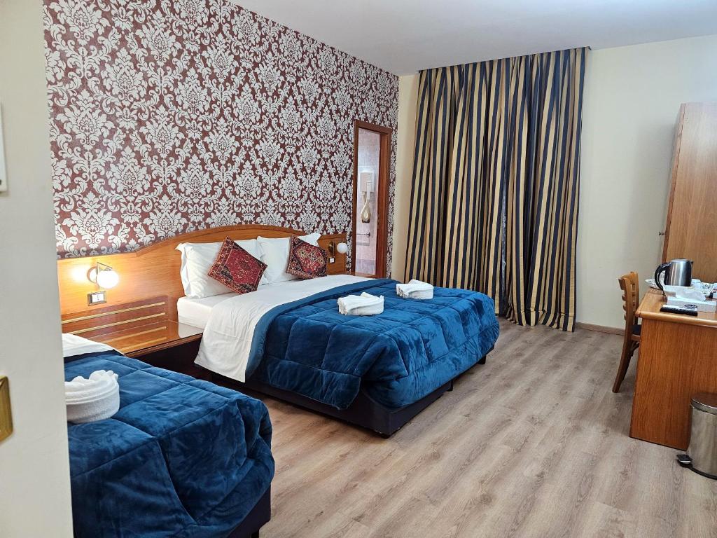 una camera d'albergo con un letto e una scrivania di Hotel Amadeus a Roma