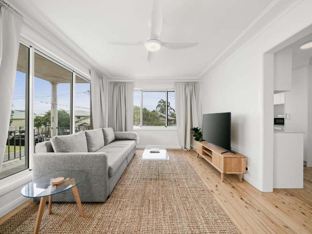 Una sala de estar con un sofá y un televisor. en Prickly Pear Stays in Merewether - Ranclaud St, en Merewether