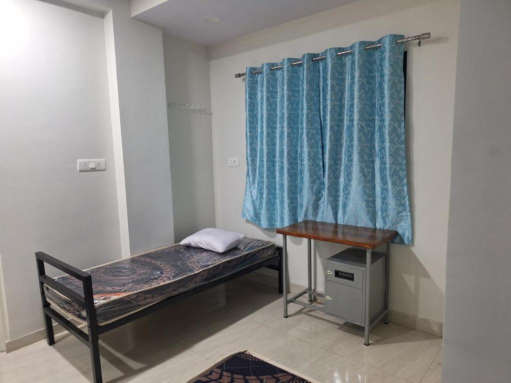 Piccola camera con letto e tenda blu di Usha Narayan a Nagpur