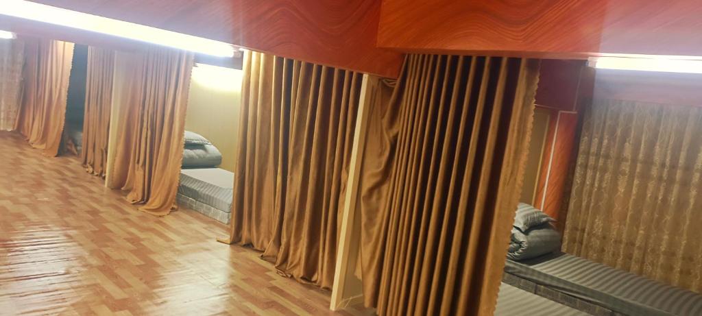 Una hilera de cortinas en una habitación con suelo de madera. en Mùa Pửi Lô lô homestay, en Mèo Vạc