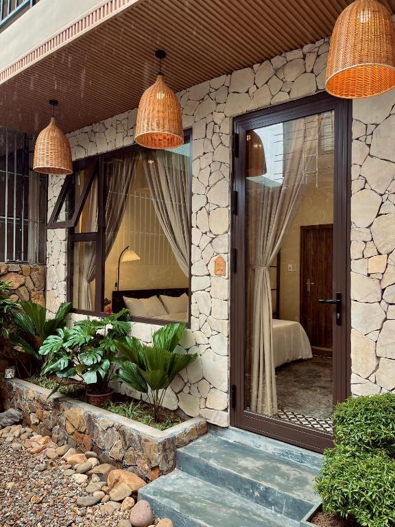 a house with a glass door leading to a bedroom at Nhà thơ Homestay in Cồn Giả Viên